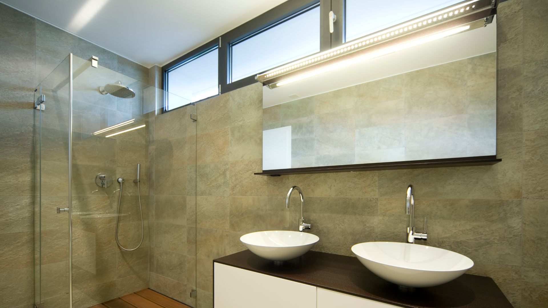 bathroom with transom windows and stone tile walls